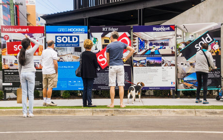 People standing in front of real estate signs