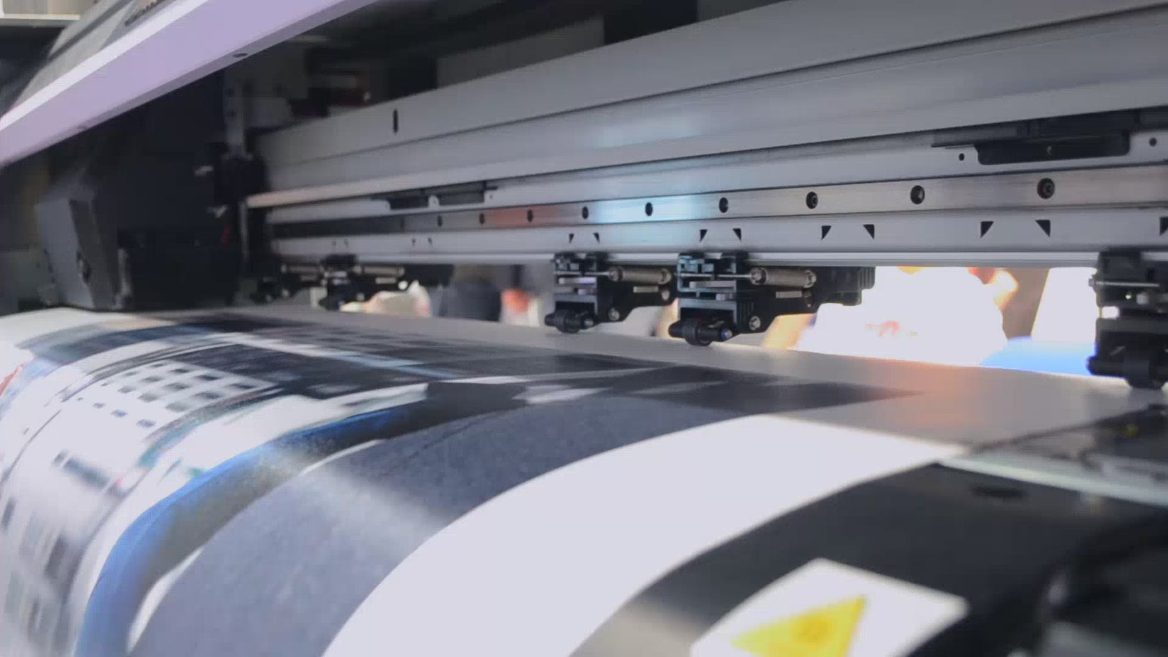 A video of a printer printing out a large format sign